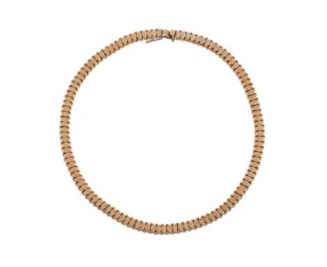 
	
		A LATE VICTORIAN GOLD COLLAR NECKLACE
		The reeded double link chain with applied oval pressed flower head panels, stamp