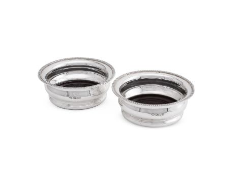 
	
		A PAIR OF SILVER MOUNTED BOTTLE COASTERS
		ELKINGTON &amp; CO., SHEFFIELD 1994
		With gadrooned borders and turned wood 
