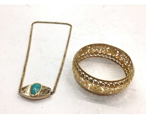 Eastern yellow metal bangle with pierced decoration, marked 'I.C. 22', together with a yellow metal turquoise pendant necklac