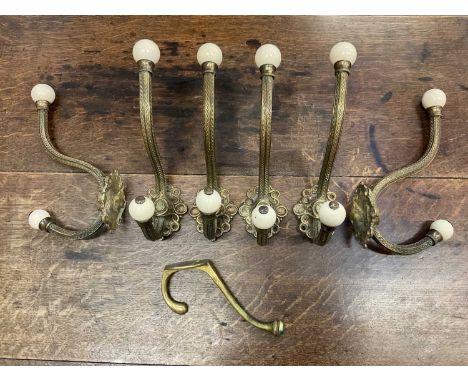 Set of six large Victorian brass coat hooks with ceramic terminals, plus one other (7)Height 22cm , depth 12cm . All in good 