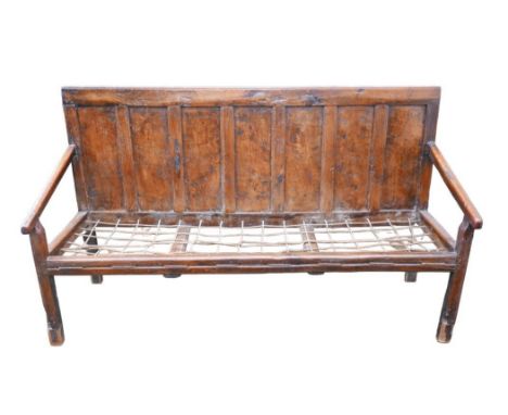 An 18th century oak settle, seven panel back, with rope seat, a/f, 179 by 55 by 104cm high. 