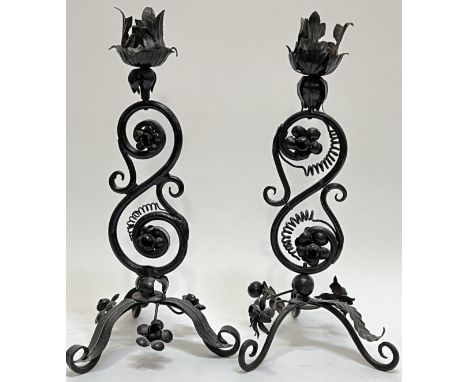 A pair of iron candlestick holders with acanthus leaf design on a scrolling stem and tripod base (h- 35cm)