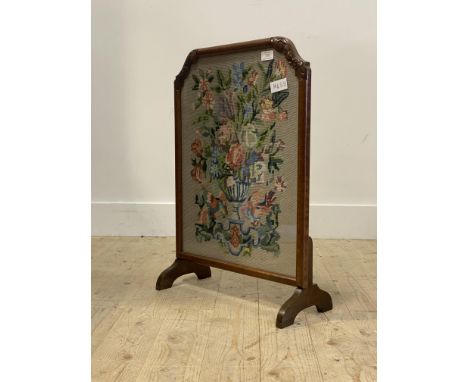 An early 20th century walnut fire screen with embroidered panel worked in a floral design, H68cm