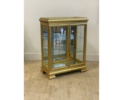A Versailles style gilt wood and composition pier cabinet, with mirrored top over glazed sides and doors enclosing a mirrored