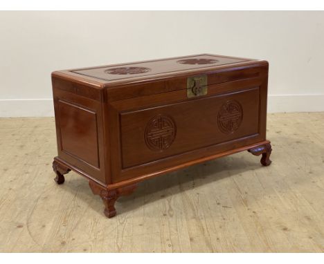 A Chinese hardwood blanket box, the lid and panelled front carved with Shou symbol motif, opening to a camphor wood lined int