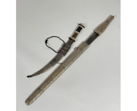 A Middle Eastern dagger, with horn and bone decorative handle, curved blade in metal covered decorative scabbard together wit