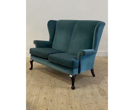 Parker Knoll, a wingback two seat sofa, upholstered in teal velvet, raised on cabriole supports H98cm, W136cm, D80cm