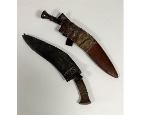 Two early 20thc. Nepalese kukris, one with horn handle, missing, one small knife in leather scabbard together with another wi