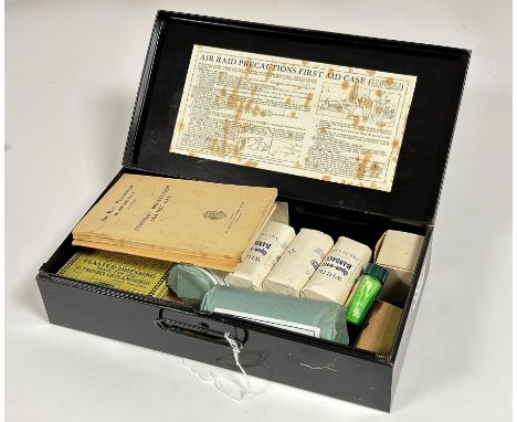 A WWII Air Raid Precautions First Aid Kit by Boots, black metal tin containing pressing bandages, handbooks etc.