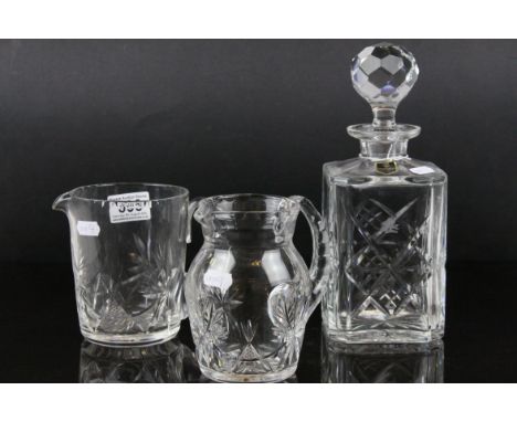 An Edinburgh crystal cut glass decanter and two similar jugs.