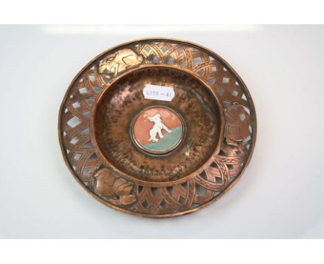 An arts &amp; Crafts copper pin dish with pierced decorative rim and enamel dog to centre.