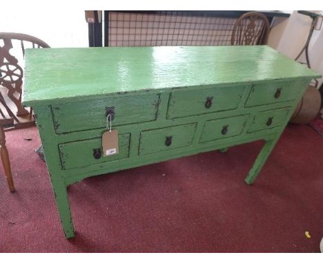 An Indonesian distressed green painted oak console table, having an arrangement of seven drawers on square legs, H.86 W.130 D