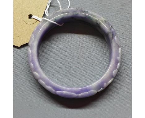 A Chinese lavender jadeite bangle, with carved scrolling foliate decoration, Diameter 6.2cm (inside) 