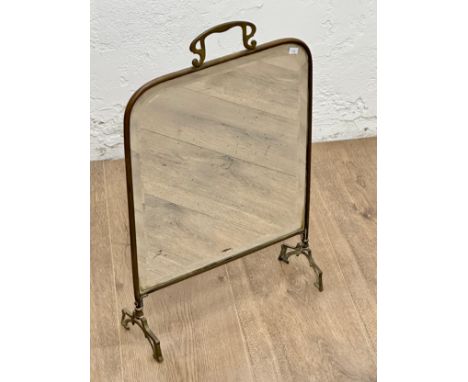 An Edwardian brass framed firescreen with bevelled glass panel.