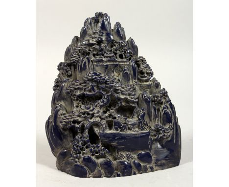 A CHINESE CARVED FAUX-LAPIS BOULDER, trees, figures, and boats. 7ins high.