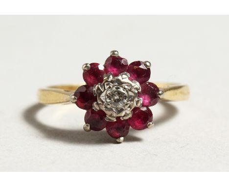 AN 18CT GOLD RUBY AND DIAMOND CLUSTER RING.