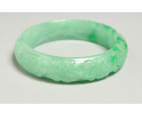 A CARVED JADE BANGLE, 7cm diameter.