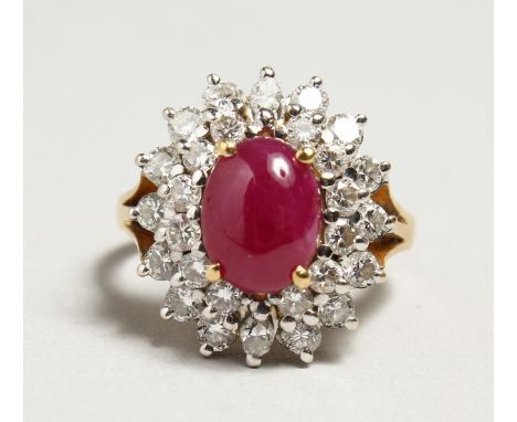 A GOLD CABOCHON RUBY AND DIAMOND CLUSTER RING.