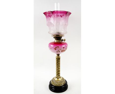 OIL LAMP, late Victorian brass and black ceramic with cranberry glass shade and floral painted reservoir, 74cm H x 23cm.
