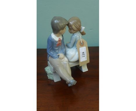 Lladro "Nao" figure of a young boy and girl seated on a bench