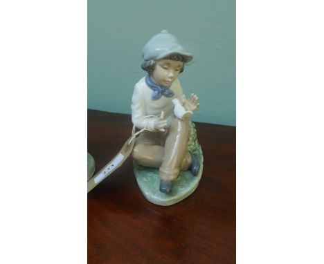 Lladro "Nao" figure of a youth with a dove on his knee and another of a girl with pixie hat training a puppy (repaired)