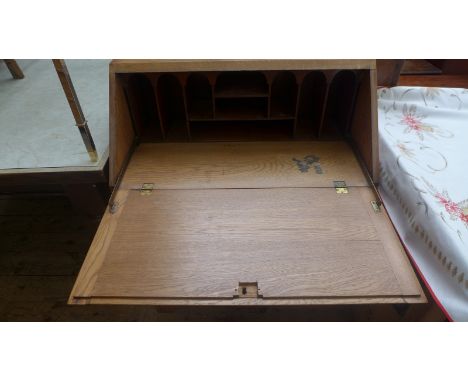 Light oak fall leaf bureau, the interior fitted open pigeon holes, central single drawer with double shelved cupboard below