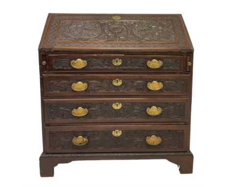 20th century mahogany bureau, the fall front enclosing fitted interior over four short drawers, all profusely carved, raised 