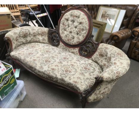 A Victorian double ended sofa with button back floral upholstery.