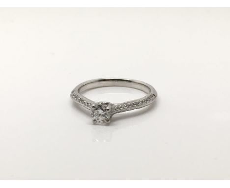 A Platinum Solitaire ring the central diamond approx .33 of a carat. The shank set with further diamonds. Ring size K.