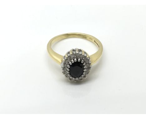 An 18carat Gold ring set with a central sapphire flanked in an oval with diamonds. Ring size L-K