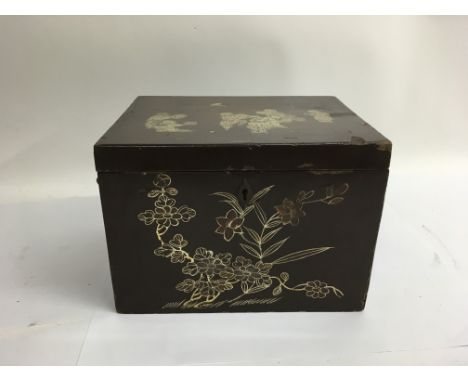 A vintage lacquered tea caddy with floral designs