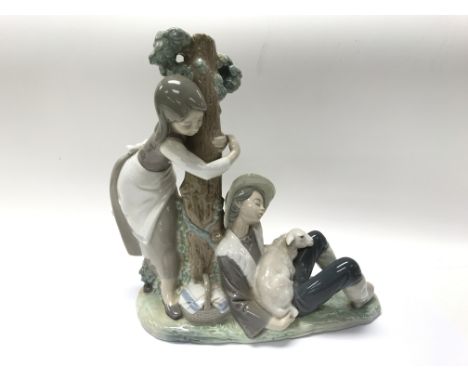 A large Lladro piece depicting figures around a tree trunk.