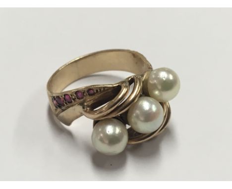 A gold ring (unmarked) set with ruby coloured stones and three pearls.  ring size N.