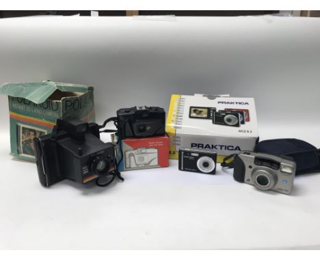 A collection of old camera equipment including a Canon and a Polaroid.