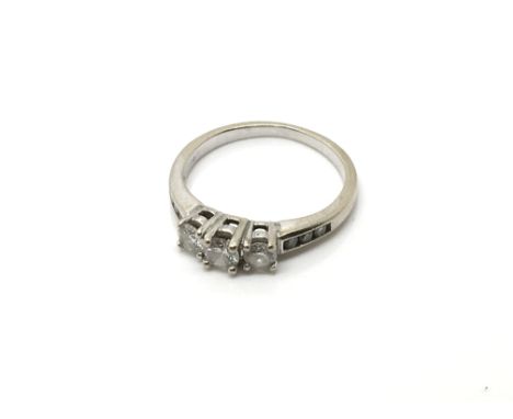 A White gold 3 stone diamond ring, with further small stones set in the shank. Ring size K.