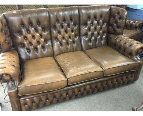 A Vintage brown  leather button back three seater sofa with matching arm chair.