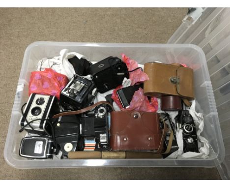 A box containing a large collection of vintage cameras including Kodak, Olympus and other camera accessories