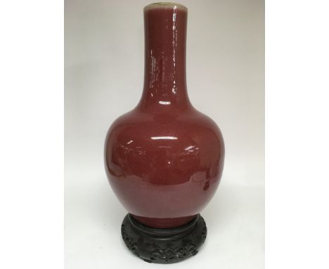 A large Chinese vase sang de boeuf bottle vase on carved wood stand.Approx 62cm inc.