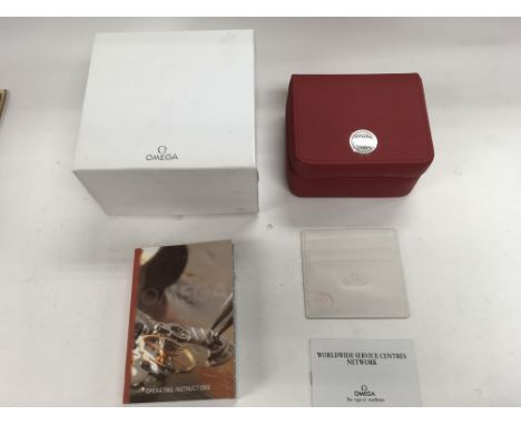 An Omega watch box with an operating instructions guide and a service centre network leaflet