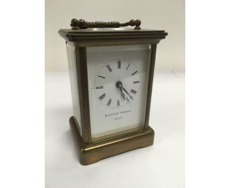 A Matthew Norman brass cased carriage clock and key, approx height 12cm.