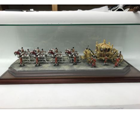 A 2003 Enesco Scotland scale model of the coronation coach for Queen Elizabeth II in a glass case (size approx 83x33x31cm)