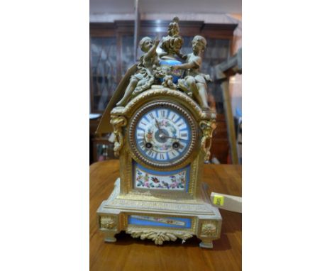 A 19th century French gilded bronze eight day mantel clock, drum movement, ceramic dial painted with Roman numerals and flora