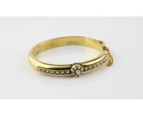 Victorian oval hinged bangle, central seed pearl cluster and seed pearl row set either side, mount stamped 15 ct gold, with c