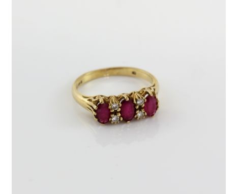 Ruby and diamond ring, three oval cut rubies set with four round brilliant cut diamonds, mounted in 9 ct yellow gold, ring si