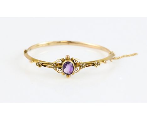 Edwardian hinged bangle, oval cut amethyst, estimated weight 2.15 carats, floral and arrow seed pearl set detail, in 9 ct gol