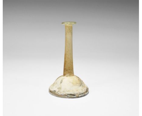 Roman Glass Candlestick Unguentarium 1st-2nd century AD. A pale amber glass unguentarium with conical base, tall tubular neck