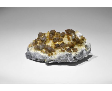 Geological Siderite on White Calcite Mineral Specimen A number of finely-formed rhombs of brown siderite (iron carbonate) res