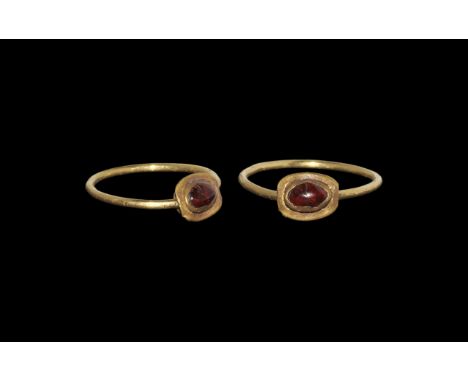Roman Gold Ring with Cabochon Garnet 1st century AD. A round-section wire hoop with elliptical cell, flange rim and inset cab
