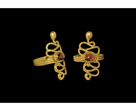 Egyptian Gold Serpent Ring with Garnet Roman Period, 30 BC-323 AD. A hoop of coiled round-section wire with s-curved tail and