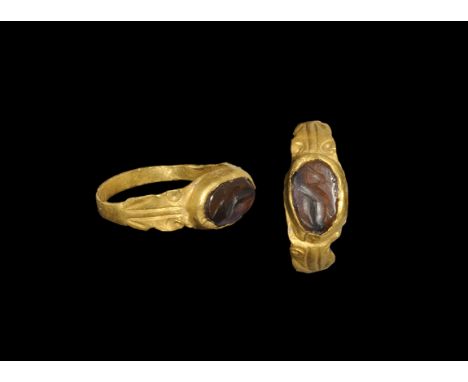Roman Gold and Garnet Decorated Ring with Crane Intaglio 3rd century AD. A flat-section hoop with flared shoulders, volute sc